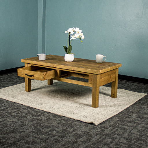 Front view of the Ventura Recycled Pine Coffee Table with its drawers open, both ways. There are two coffee mugs and a pot of white flowers on top.