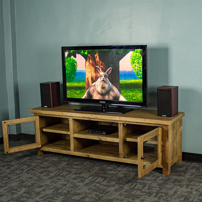 An overall view of the Ventura Recycled Pine Medium TV Unit with its drawers open,. There is a TV on top, with two bookcase speakers on either side and a DVD player on the top shelf in the middle of the unit.