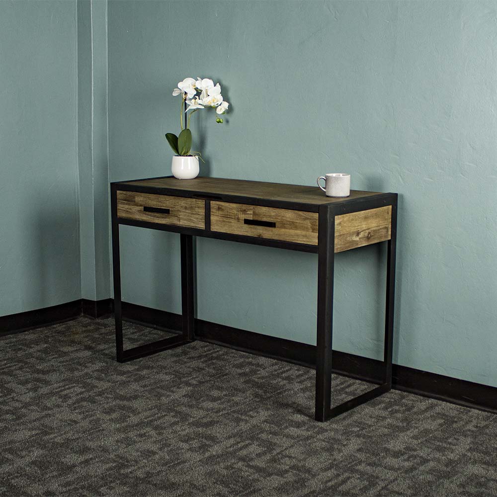 The front of the Victor Dressing Table / Desk with its drawers closed. There is a small pot of white flowers and a coffee cup on top.