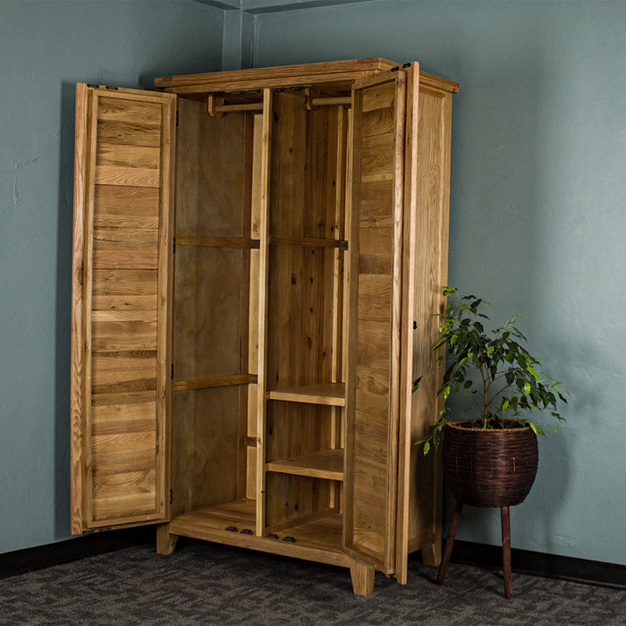 The front of the Vienna Oak Large Wardrobe with its doors open. There is a free standing potted plant next to the wardrobe.