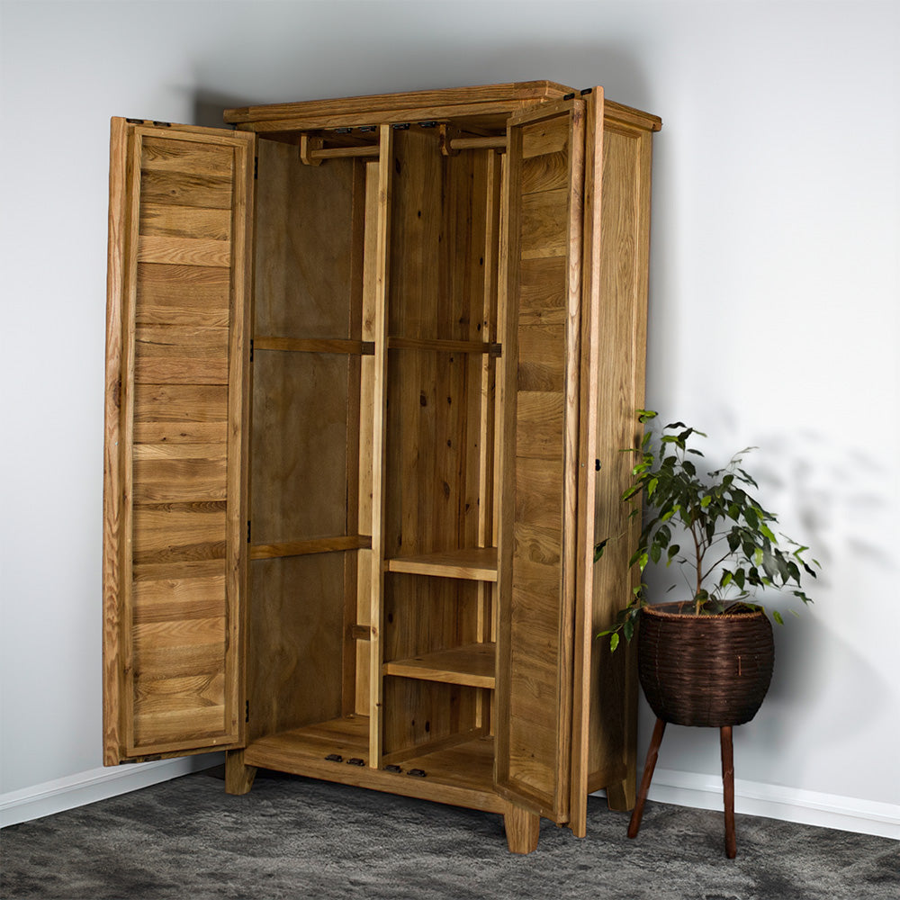 The front of the Vienna Oak Large Wardrobe with its doors open. There is a free standing potted plant next to the wardrobe.