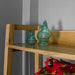 A close up of the top shelf on the Kubic Oak Display Shelf, there are two blue glass ornaments in the shape of chickens on the shelf.