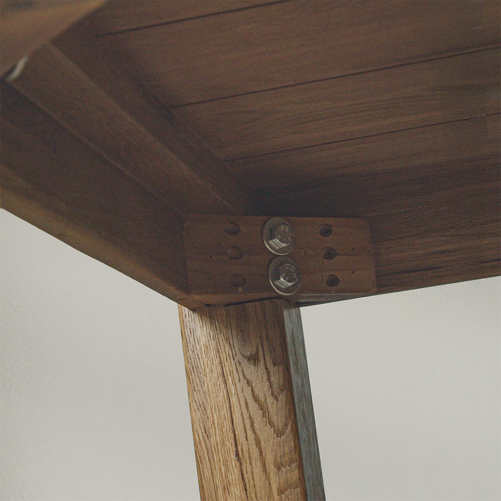 A close up of the bolts that securely hold the legs of the Amstel Square Oak Coffee Table to the body.