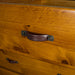 Close up of the leather and bolted metal handle of the Jamaica 6 Drawer Pine Tallboy