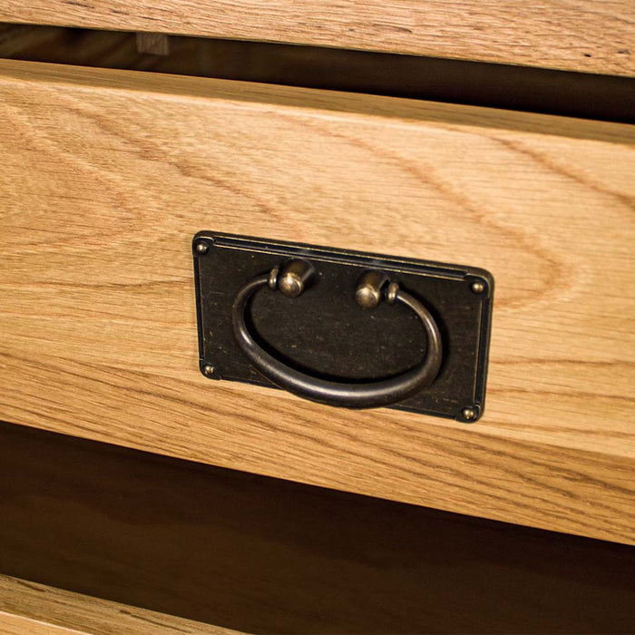 A close up of the brushed black metal handle on the drawers of the Vienna 7 Drawer Oak Tallboy.