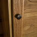 A close up of the brushed black metal handle on the door of the Vienna Oak Large Wardrobe.
