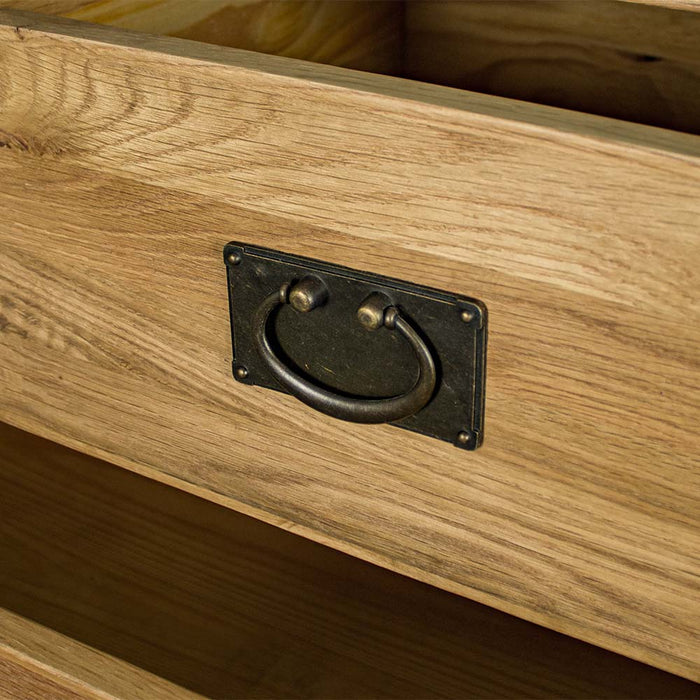 A close up of the hanging-style metal handle on the drawers of the Yes Five Drawer Oak Chest.