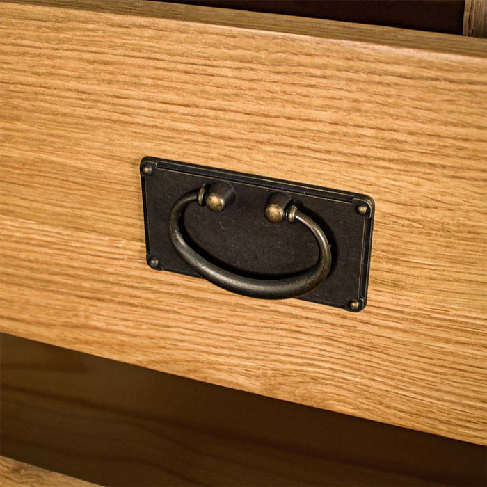 A close up of the brushed black metal handle on the Yes Four Drawer Oak Tallboy