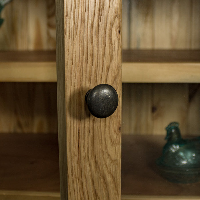 A close up of the charcoal black metal handle on the door of the Yes Oak Display Cabinet.