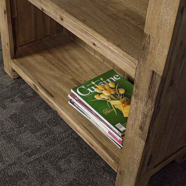 A low angle view of the shelving on the Mars Large Bookcase. There is a stack of magazines on the shelf.