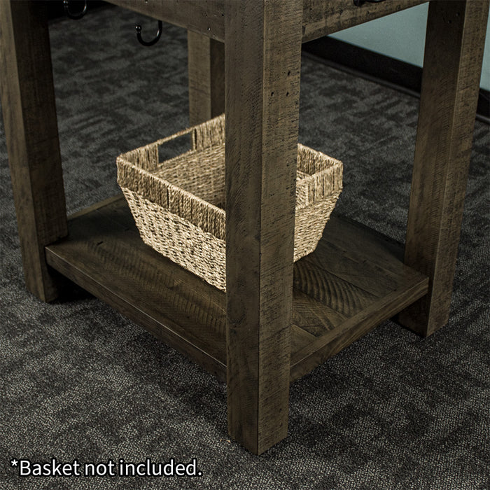 Lower shelf of the Stonemill Recycled Pine Granite Workbench, there is a woven basket sitting on it.