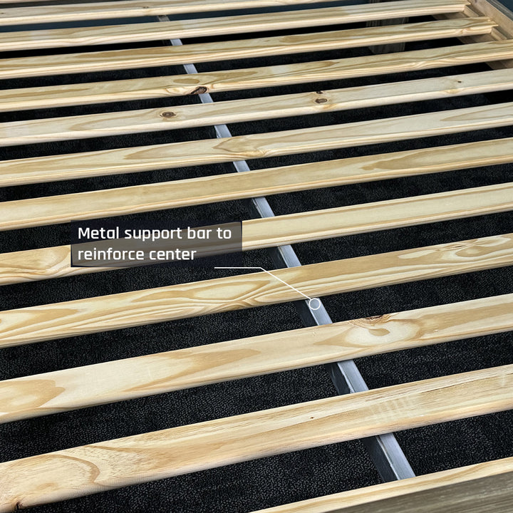 The slats of the Vancouver Queen Size NZ Pine Slat Bed Frame, with a metal support bar running underneath.