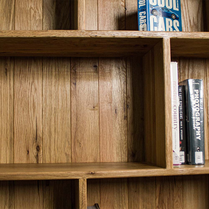 A close up of the Versailles Outback Oak Three Level Bookcase, showing the tongue and groove back panelling.