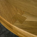 Close up of the top of the Amstel Round Oak Dining Table, showing the wood grain and dovetail joinery.