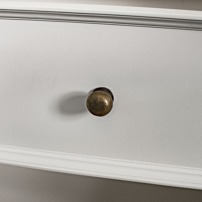 A close up of the brushed brass metal handle on the drawers/doors on the Biarritz Two-piece Wardrobe.