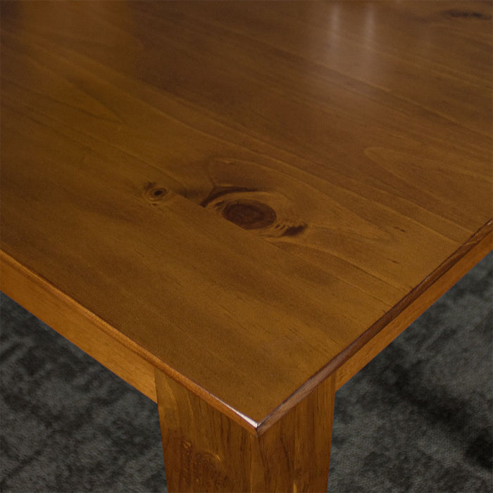 A close up of the Hamilton Dining Table with Rimu Finish (1200mm) showing the wood grain and smooth rimu stain.