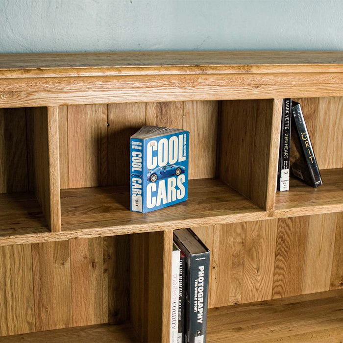 The top shelf of the Versailles Outback Oak Three Level Bookcase. There is a blue book in the middle labelled "Cool Cars".