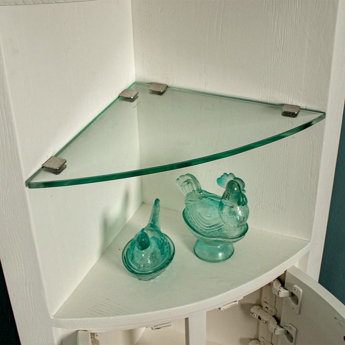 A view of the thick blue glass shelf. There are two blue glass ornaments below it in the shape of chickens.
