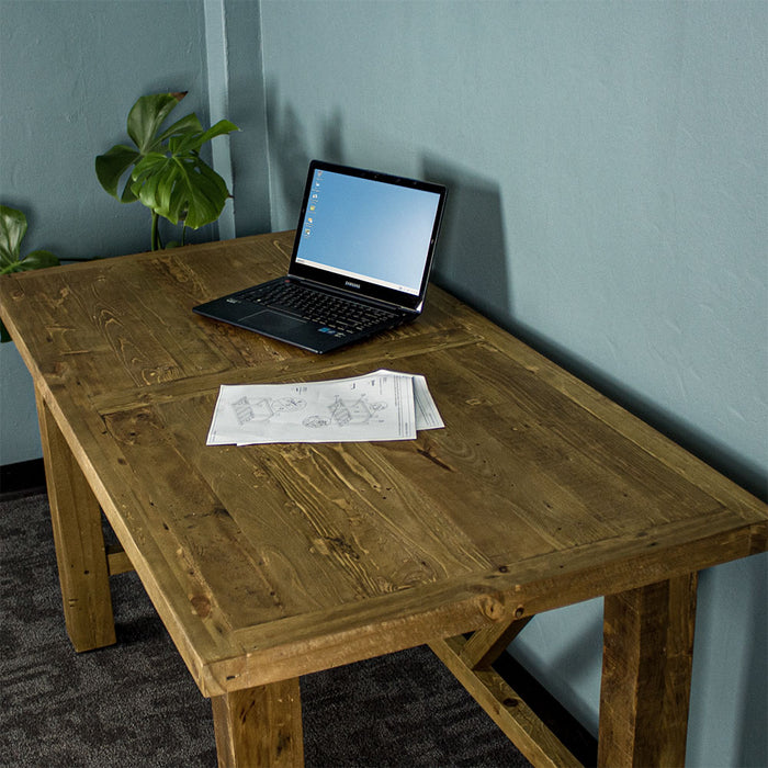 Overall view of the top of the Ventura Recycled Pine Desk. There is a pile of papers, and a laptop on top.