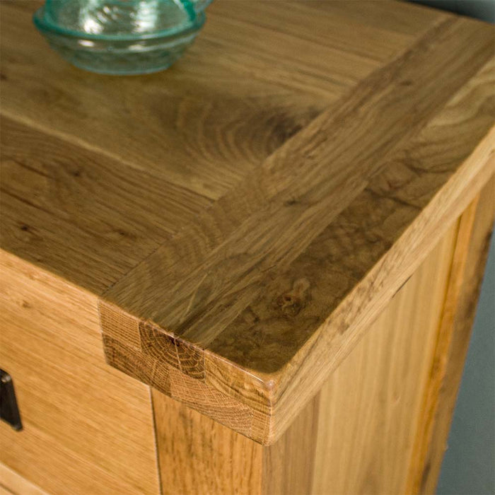 A close up of the top of the Yes Four Drawer Oak Tallboy, showing the wood grain and colour.