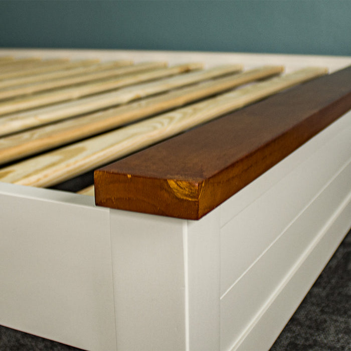 The rimu stained top of the footboard/headboard on the Alton Queen Size Pine Slat Bed Frame.