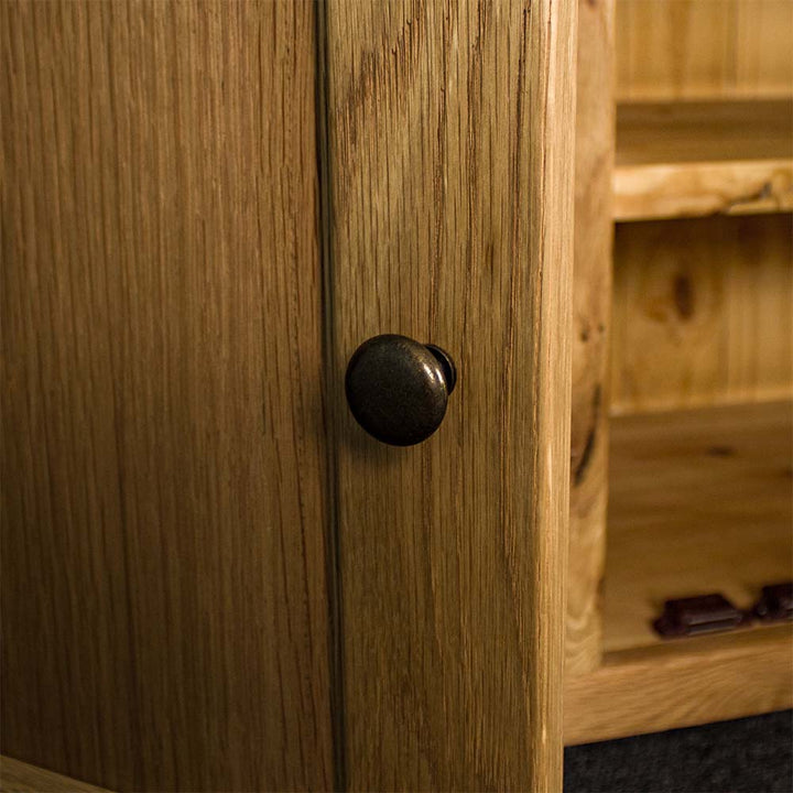 A close up of the brushed black metal handle on the Yes 3 Door 3 Drawer Oak Buffet.