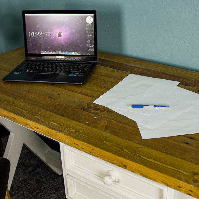 An overall view of the top of the Byron Recycled Pine Desk. There is a laptop and a pile of papers with a pen on top of the desk.