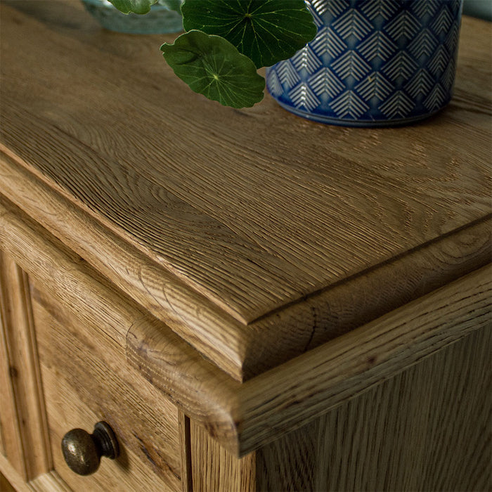 A close up of the top of the Versailles Oak 7 Drawer Chest, showing the wood grain.