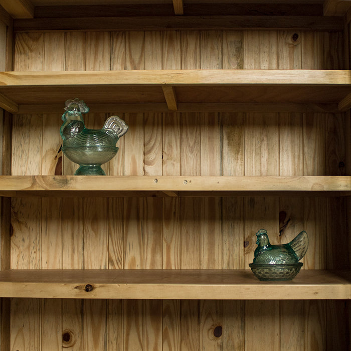 An overall view of the shelves on the Yes Oak Display Cabinet. There are two blue glass ornaments in the shape of a chicken on the two middle shelves.