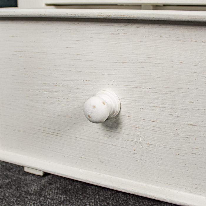 A close up of the doorknob style handle on the Tuscan Recycled Pine Tall Bookcase. The drawer and handle are both painted white.