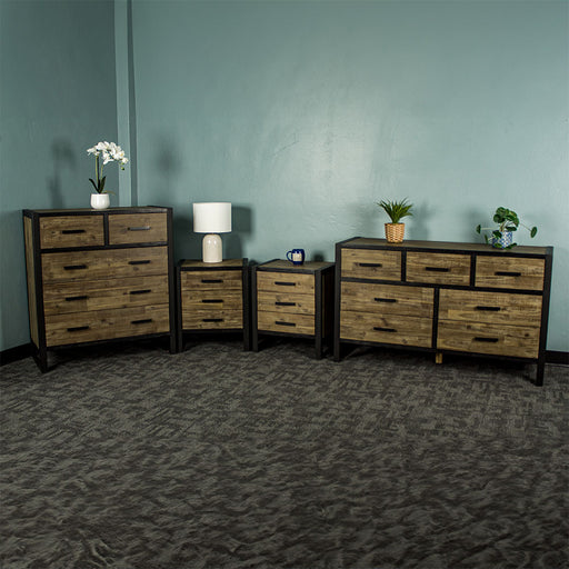 From left to right: Victor 5 Drawer Tallboy, two Victor 3 Drawer Bedside Cabinets and a Victor 7 Drawer Lowboy. There is a small pot of flowers on the tallboy, a lamp on the left bedside, a blue coffee mug on the right bedside, and two potted plants on the lowboy.