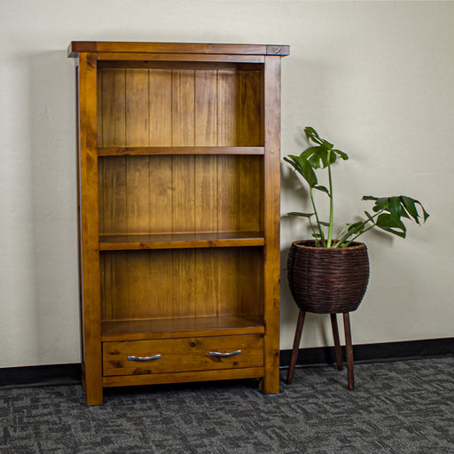 The front of the Monaco Bookcase. There is a free standing potted plant next to it.