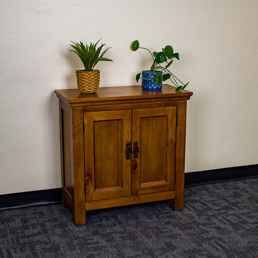 The front of the Montreal Compact Pine Buffet. There are two potted plants on top.