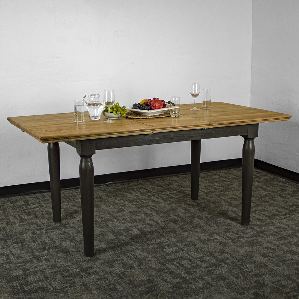 An overall view of the Boston Oak Extending Dining Table. There is a water pitcher and several glasses on top, as well as a platter of fruit.