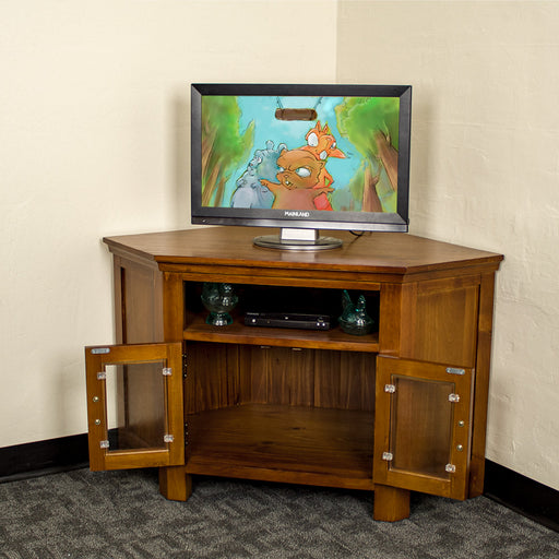 The front of the Montreal Pine Corner Entertainment Unit with its doors open. There is a TV on top, and two blue glass ornaments with a DVD player in between on the top shelf.