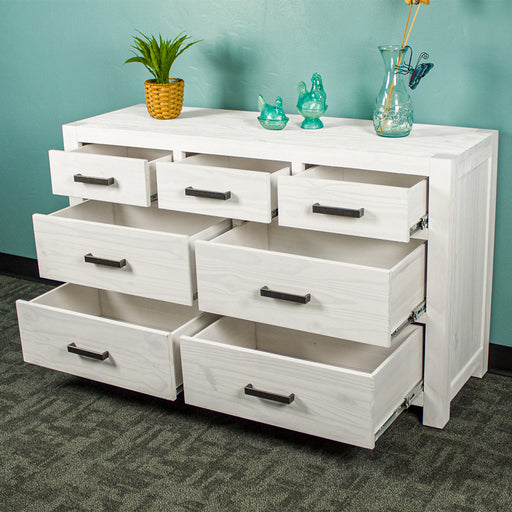 The Vancouver 7 Drawer White Lowboy with its drawers open. There is a potted plant and three blue glass ornaments on top.
