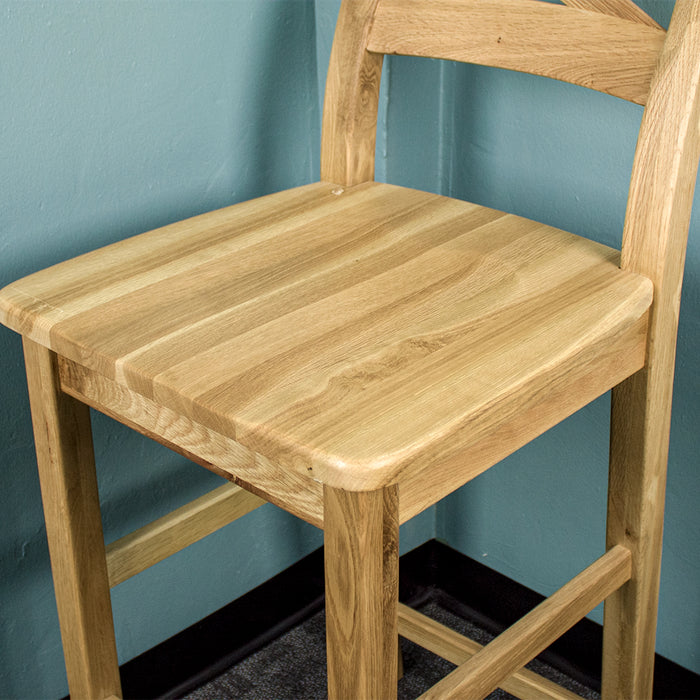 A close up of the top of the Maximus Oak High Bar Stool, showing the wood grain and colour.