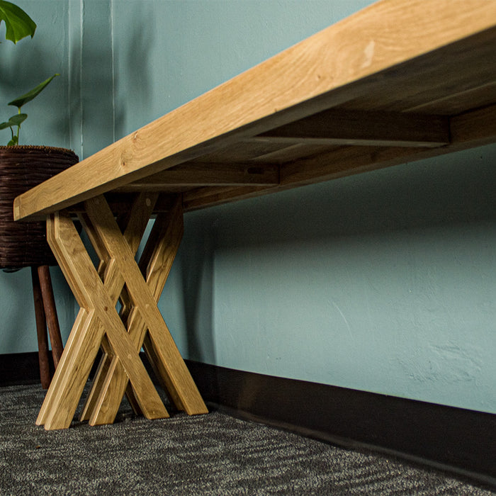 A view from under the Arpege Oak Cross Leg 2m Bench Seat, showing the strong crossed legs.