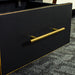 A close up of the gold coloured metal handle on the drawer of the Cascais Tall Black Bookcase.