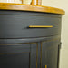 A close view of the gold coloured metal handle on the drawer of the Cascais Oak-Top Corner Cabinet.
