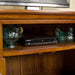 A closer view of the shelf on the Montreal Pine Corner Entertainment Unit. There are two blue glass ornaments on either side of a DVD player.