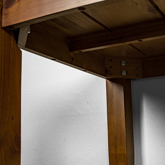 A view of under the Hamilton Pine Dining Table (800mm), showing the bolts that securely hold the legs to the body.