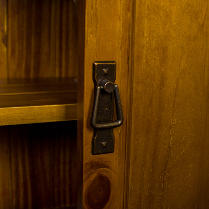 A close up of the hanging door handle on the door of the Montreal Compact Pine Buffet.