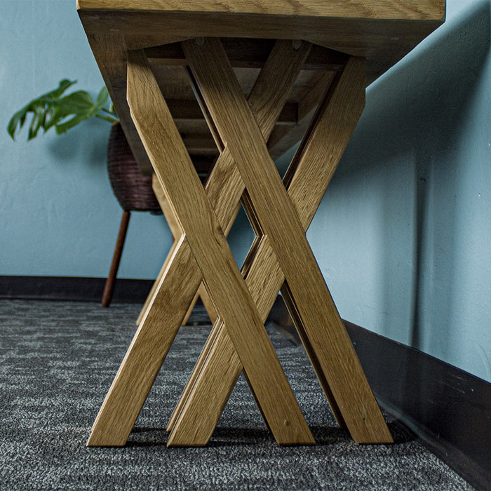 A front on view of the cross legs on the Arpege Oak Cross Leg 2m Bench Seat.