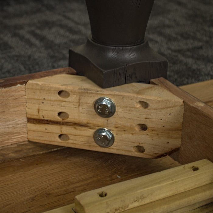 A close up of the bolts that securely hold the legs to the body of the Boston Oak Dining Table.