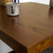 A close up of the top of the Hamilton Pine Dining Table (800mm). There is a coffee mug on top.