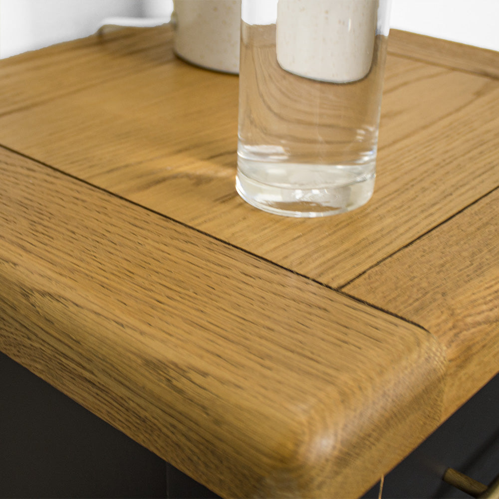 A close up of the top of the Cascais 3 Drawer Black Bedside Table, showing the wood grain and colour.