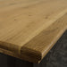A close up of the top of the Boston Oak Large 2m Dining Table, showing the wood grain and colour.